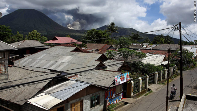 The Mount Lokon volcano spews thick smoke and ash into the air as seen from the town of Tomohon on Sunday.