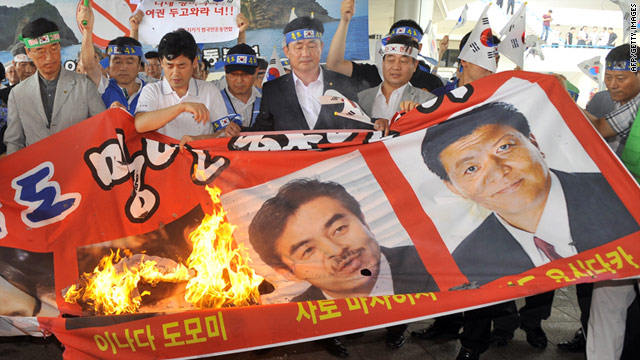 South Korean protesters burn a banner showing three Japanese lawmakers ahead of their arrival in Seoul.