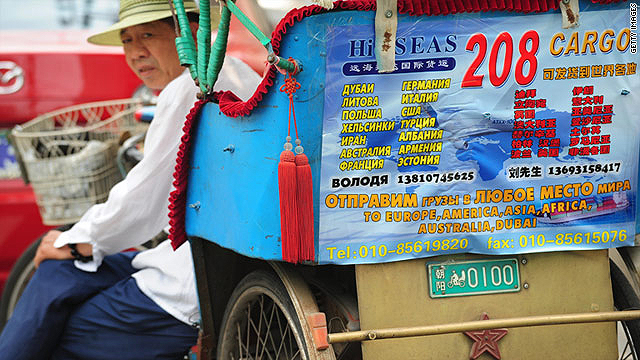A driver's pedicab, adorned with Russian advertising in Cyrillic and Chinese, sits waiting for customers in Beijing's Yabaolu.