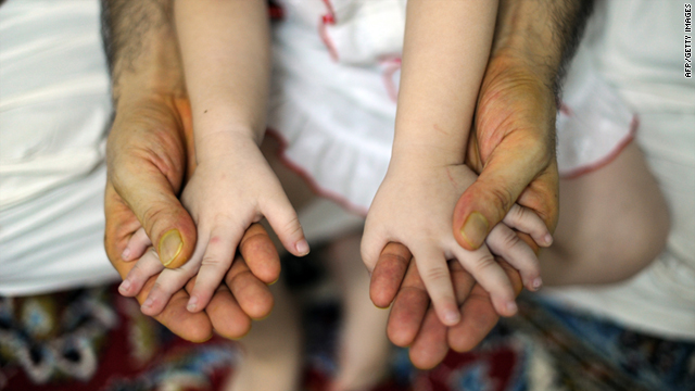 An Afghan migrant seeking a better future in Australia holds his daughter in an interview in Kuala Lumpur on August 18, 2011.
