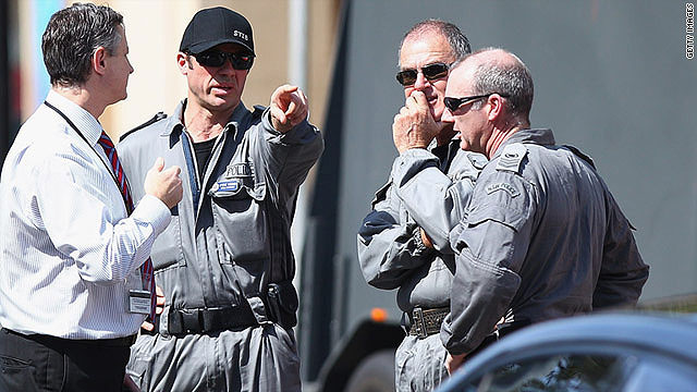 Ambulance and bomb squad members stand outside a purported hostage situation in Sydney, Australia.