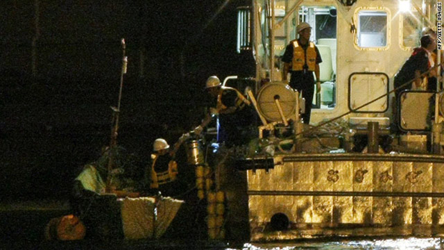 Japan Coast Guard officers check a small boat which carried the nine possible North Korean defectors at Kanazawa port.