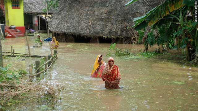 Indian villagers wade though flood waters near Mahanga Panchayat in Orissa's Cuttack district on September 13, 2011.