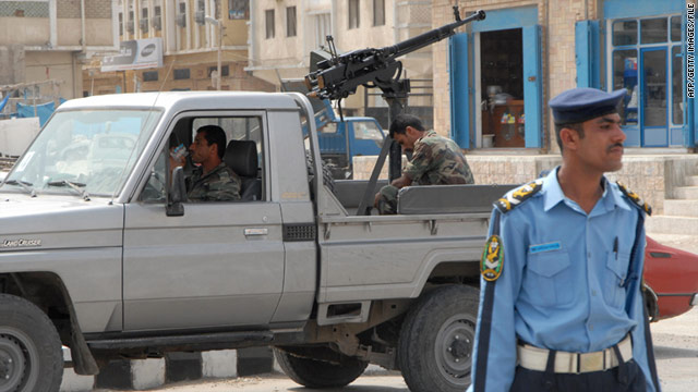 Police stand guard in the Yemeni city of Mukalla, where 63 prisoners escaped last week.