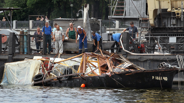Rescue workers examine the wreckage of the sunken boat in the Moskva river in Moscow, Russia, on July 31.