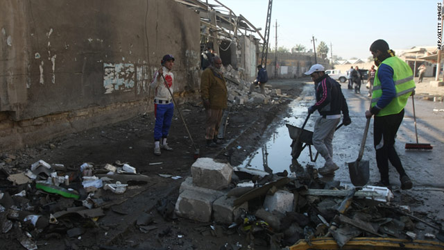 Iraqi workers clean the site of a car bomb attack in the central Karrada district of Baghdad on January 23, 2011.