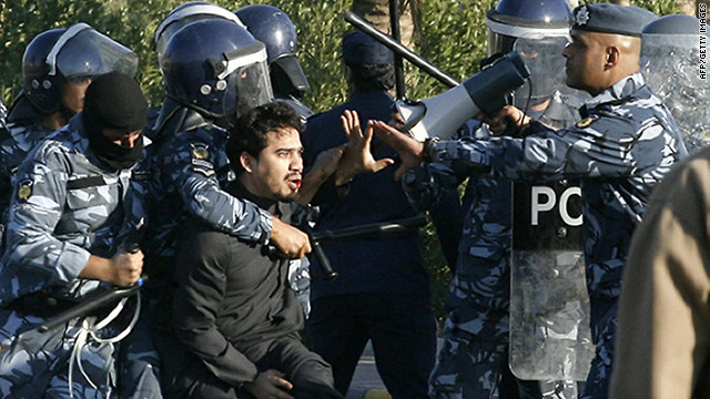 Kuwaiti riot policemen detain a man during clashes Friday between police and stateless Arab protesters in Jahra City.