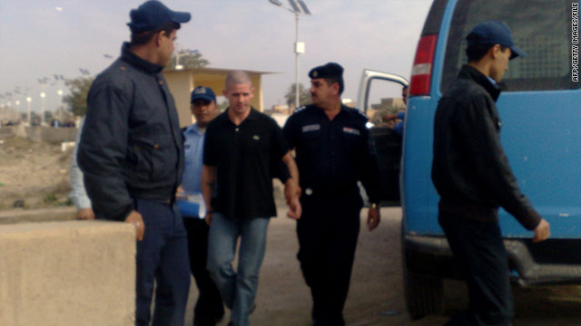 Daniel Fitzsimons, center, is escorted by Iraqi police in Baghdad after a court appearance in January.