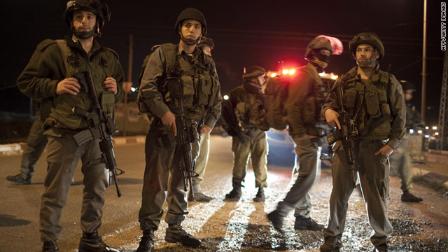 Israeli soldiers block the road in the Hawara checkpoint near the West Bank city of Nablus on Saturday, March 12.