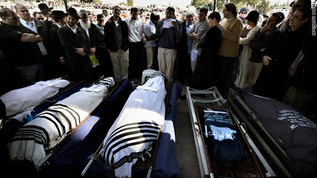 Relatives and friends mourn over the bodies of five murdered Israeli settlers on Sunday in Jerusalem's cemetery.