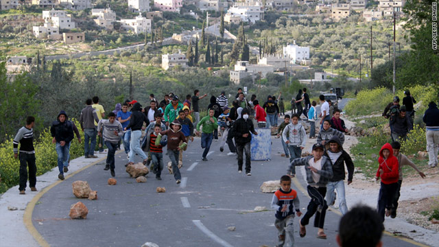 Palestinian youths run for cover during clashes with Israeli soldiers near Nablus on Tuesday, March 22.