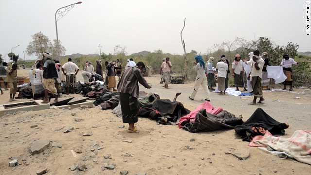 Yemenis line up bodies after the blast at an ammunition factory in Abyan Province on Monday, March 28.