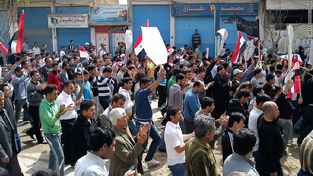 Syrian anti-government protesters march in the northeastern town of Qamishli on Friday, April 1.