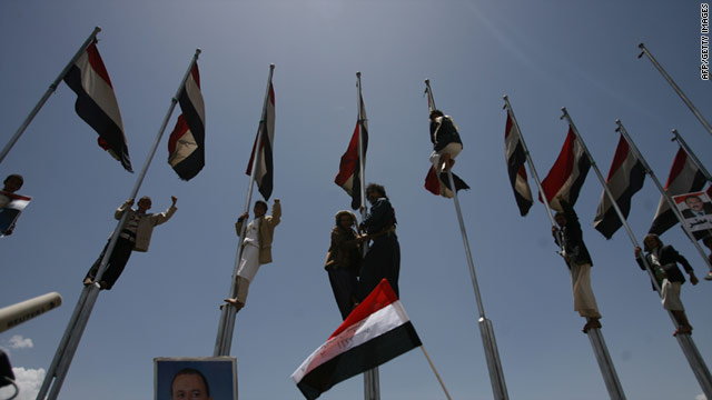 Supporters of President Ali Abdullah Saleh climb on flag poles during a rally held in the capital Sanaa on April 15, 2011.