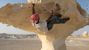 Nicknamed "Monkey" by some, Tik Root climbs in Egypt's White Desert.