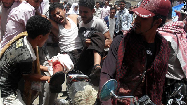 Protesters evacuate a wounded demonstrator on a motorcycle in Taiz on Monday during clashes with security forces.