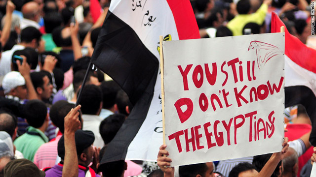 Egyptians crowd the streets, holding signs and waving the national flag, during a protest in Alexandria, Egypt, on Friday.