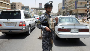 An Iraqi police officer works at a checkpoint in Baghdad, a day after five U.S. soldiers were killed.