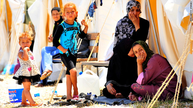 Syrian refugees sit in front of their tents Saturday in the southern part of Turkey.