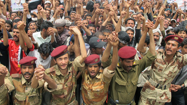 Members of the Yemeni security forces join anti-government protesters during a demonstration in Sanaa on June 20.
