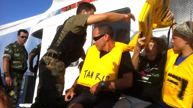 Activists sit onboard the Gaza-bound the Tahrir while it commandeered and towed by Greek Coast Guards.