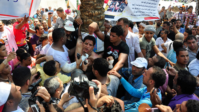 Protesters surround a man alleged to be one of several armed men who tried to attack them in Cairo's Tahrir Square on Tuesday.