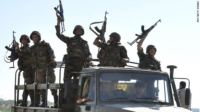 Syrian troops shout pro-government slogans as they leave Hama on Wednesday