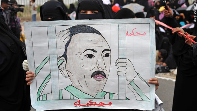 A Yemeni anti-government protester holds a drawing calling for the trial of President Ali Abdullah Saleh on August 12, 2011.