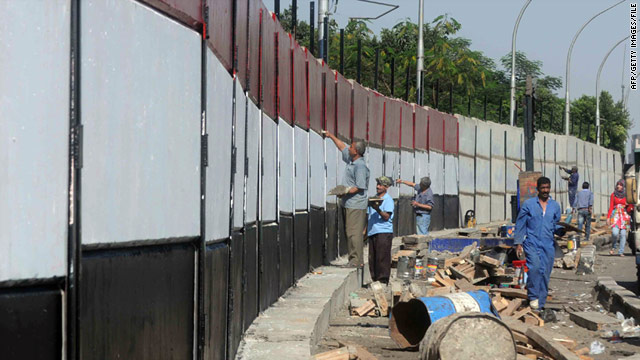 Workers paint Egyptian colours on the wall built to protect the Israeli Embassy in Cairo (file picture)
