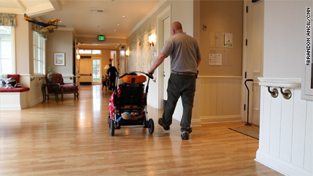 Volunteer George Warren wheels a young patient through George Mark.