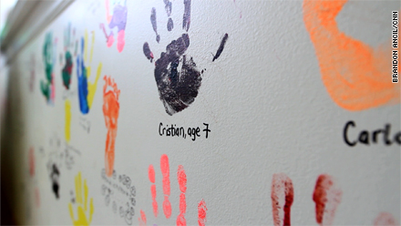 Handprints of former patients and family members at the George Mark house decorate an activity room wall.