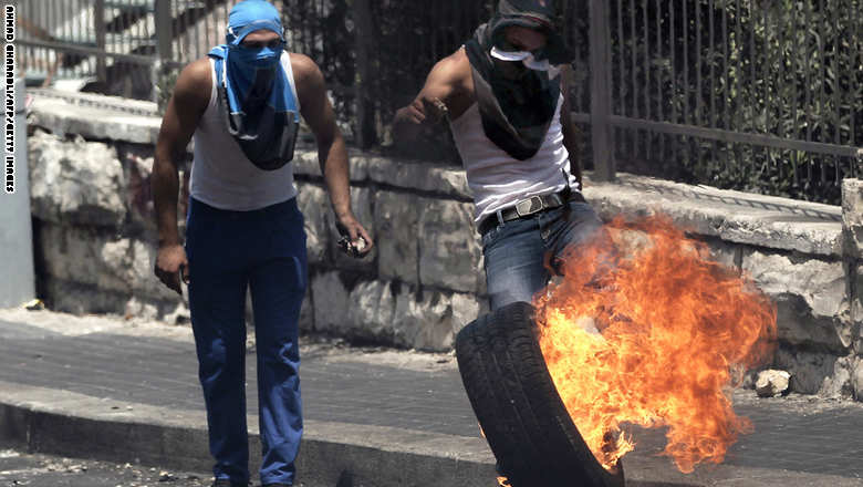 فلسطينيان يشعلان إطارا في القدس