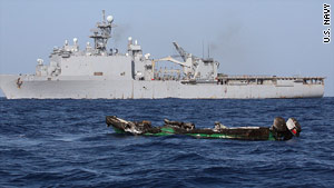 The burned hull of a suspected pirate skiff drifts near the USS  Ashland after an attack on the Ashland on April 10.