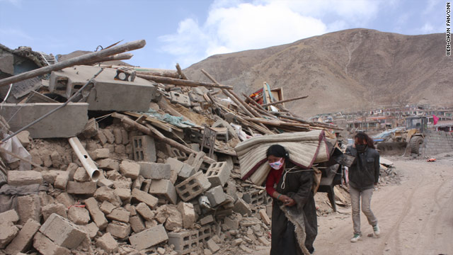 Survivors of Wednesday's earthquake move past heaps of rubble in  Yushu County, China.