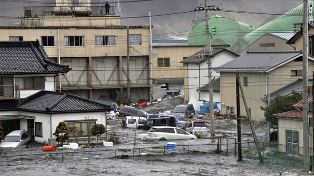 A tsunami smashes vehicles and houses in Kesennuma city in Miyagi Prefecture in northern Japan on Friday.