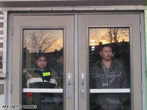 عمال يقفون خلف أبواب المصنع الذي احتلوه بشيكاغو