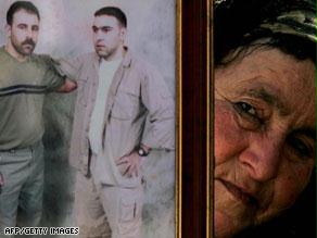 سيدة فلسطينية تحمل صورة معتقلين لدى إسرائيل