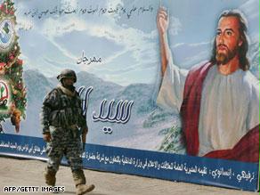 جندي عراقي يمر أمام ملصق لأعياد الميلاد