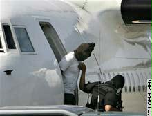إنزال أحد المشتبه بهم من الطائرة لنقله إلى مركز أمني داخل العاصمة جاكرتا