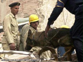 عمال إنقاذ يحاولون انتشال ضحايا انهيار عقار بمصر