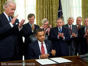 أوباما أثناء توقيع القرار وبجواره نائبه جو بايدن وعدد من مسؤولي إدارته الجديدة