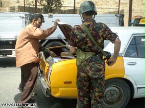 عنصر من قوات الأمن اليمنية يجري تفتيشاً لإحدى السيارات في صنعاء