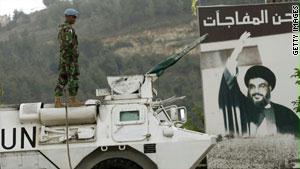 دورية تابعة للأمم المتحدة إلى جوار صورة لأمين عام حزب الله، حسن نصر الله، في جنوب لبنان