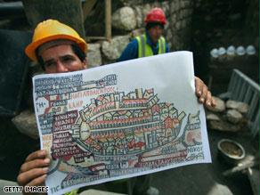 أحد عمال الحفريات يعرض خريطة مادبا