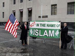 مسلمان يرفعان لافتة أمام المحكمة تفيد بأن الإسلام بريء من مثل تلك العمليات