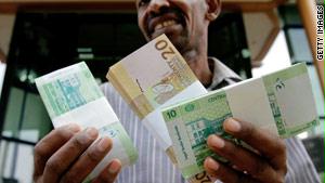 سوداني يحمل العملة الجديدة