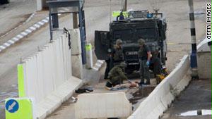 عناصر من الجيش الإسرائيلي يفحصون جثة القتيل