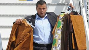 مساعد للقذافي يهبط سلم طائرة حاملا بذلات الزعيم الليبي