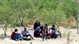 لاجئون سوريون بانتظار العبور إلى الأراضي التركية