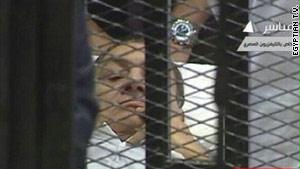 كان مبارك يلعب بأنفه تارة ويغطي فمه ووجهه تارة أخرى
